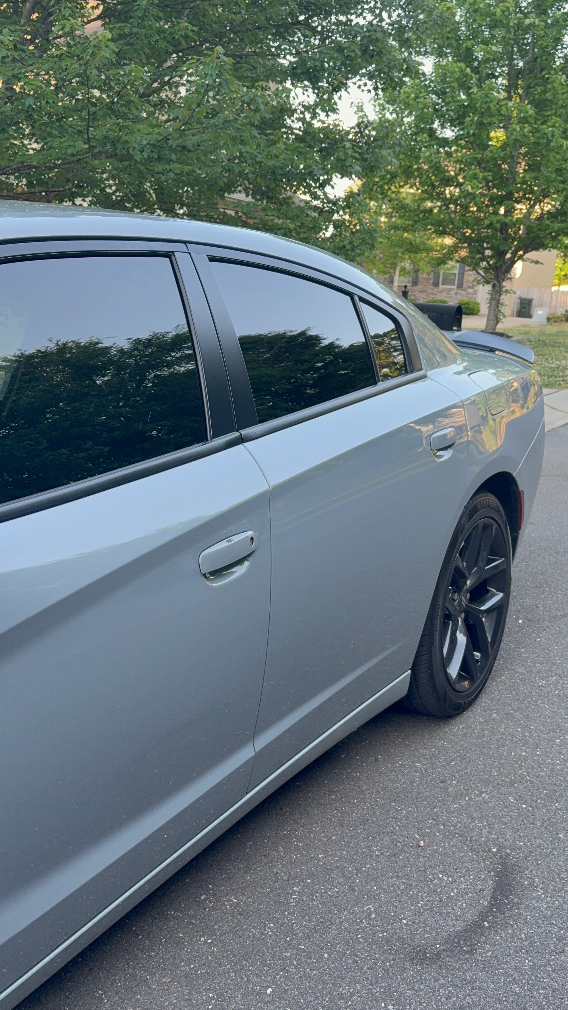 Side of a silver Dodge Charger with clean glass and wheels